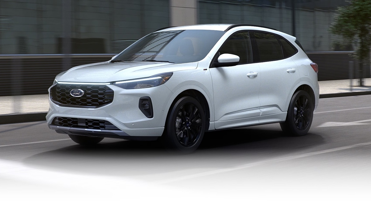 White Ford Escape hybrid in motion on an urban road, offering a dynamic view of the front of the vehicle with sporty black rims.