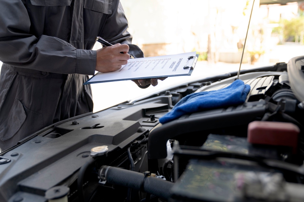 Un garagiste qui fait la liste d'entretien pour une auto.