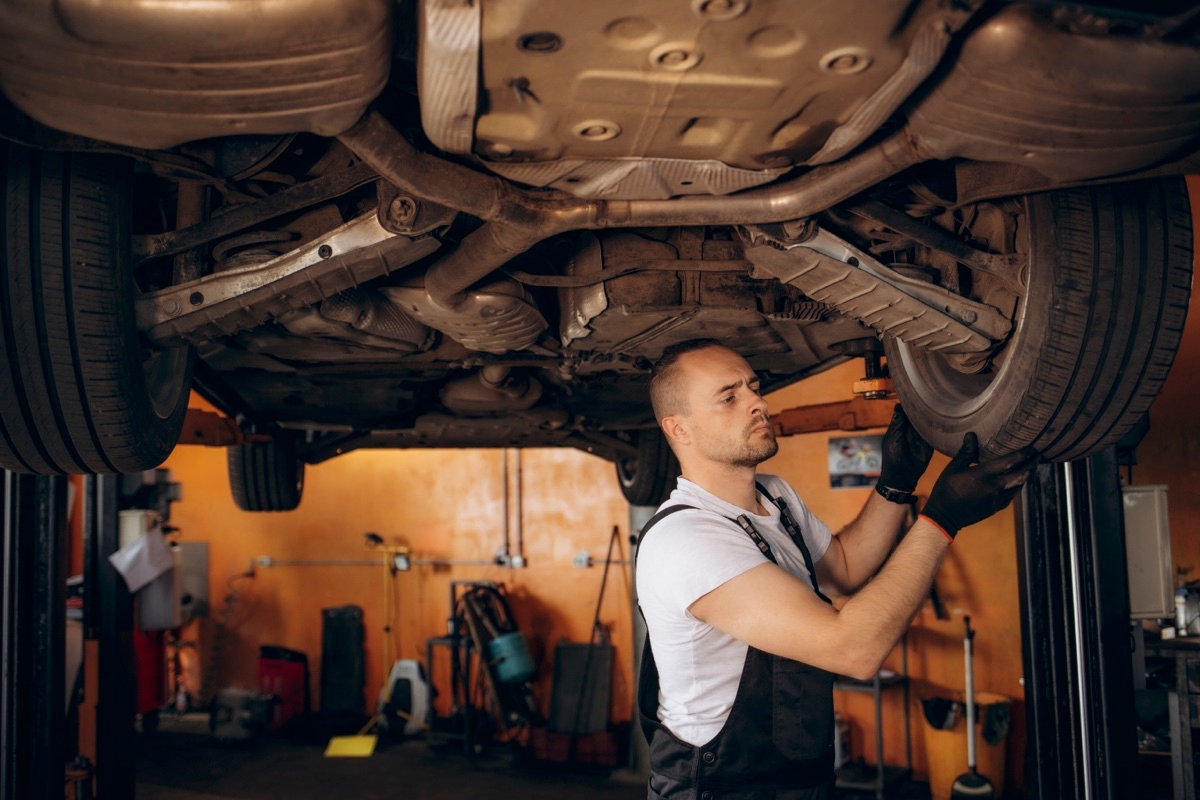 Un garagiste en train de faire une inspection de voiture.