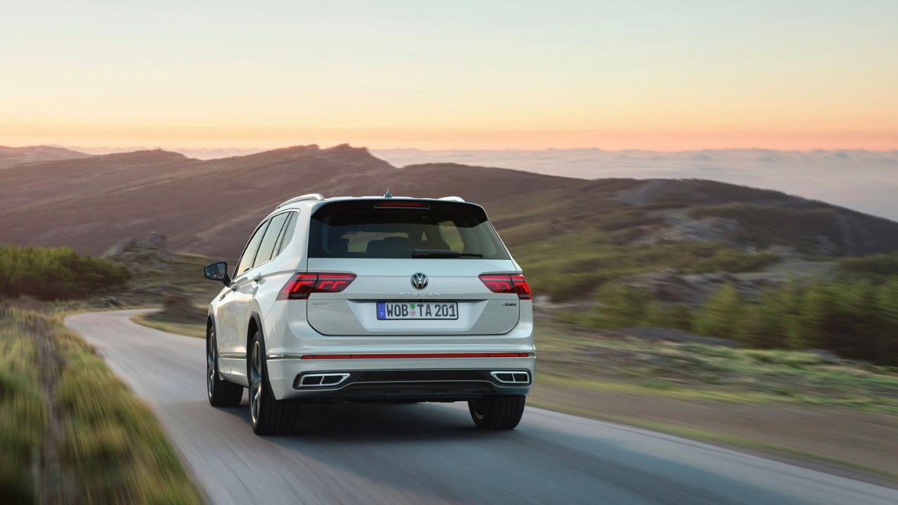 Le Volkswagen Tiguan 2023 vue de l'arrière avec un arrière plan de montagne au couché du soleil.