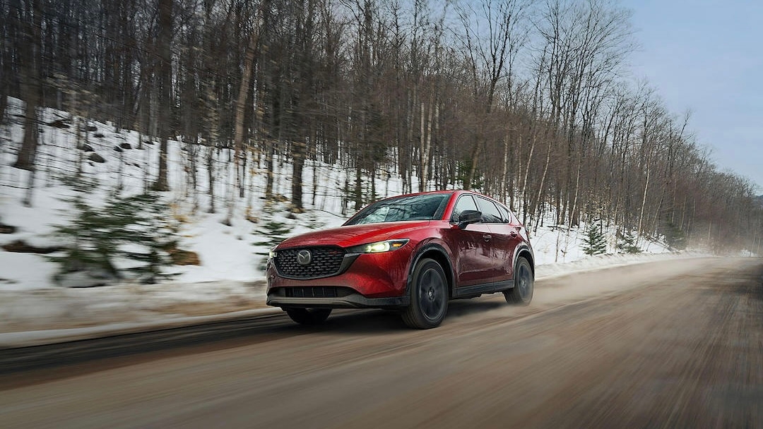 Un Mazda CX5 roulant en forêt pendant l'hiver.